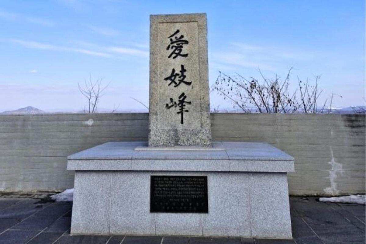 sebuah monumen dengan tulisan di depannya di depan dinding