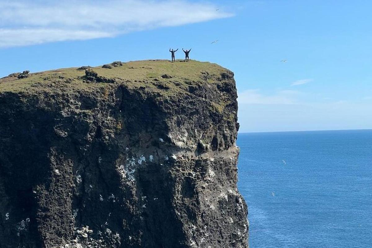 dua orang berdiri di atas gunung berbatu