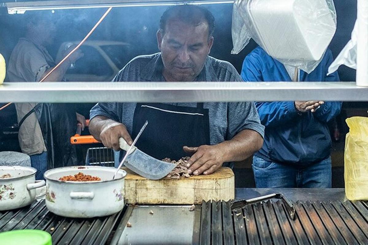 un hombre cocinando comida en una olla sobre una parrilla