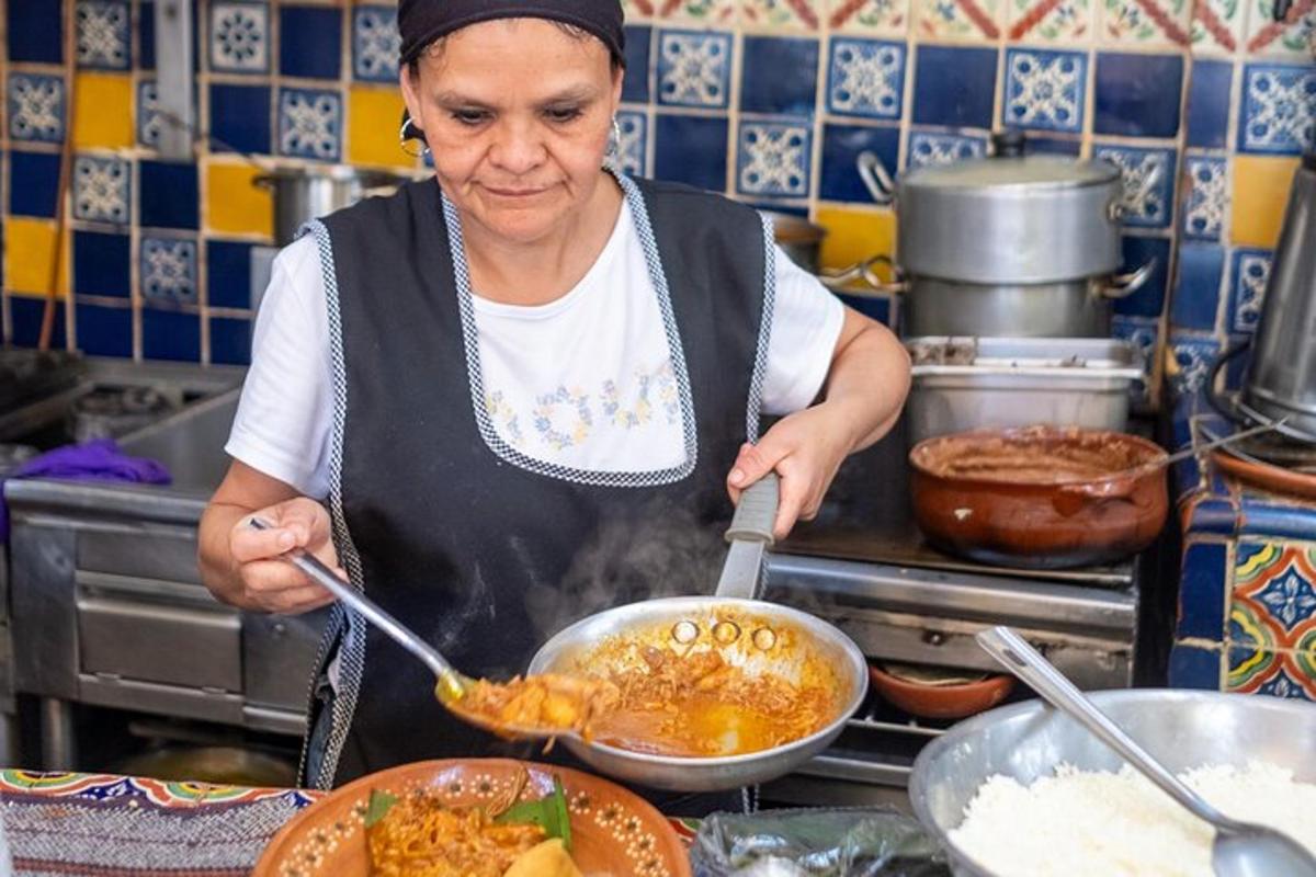 Μια γυναίκα μαγειρεύει φαγητό σε ένα τηγάνι σε μια κουζίνα