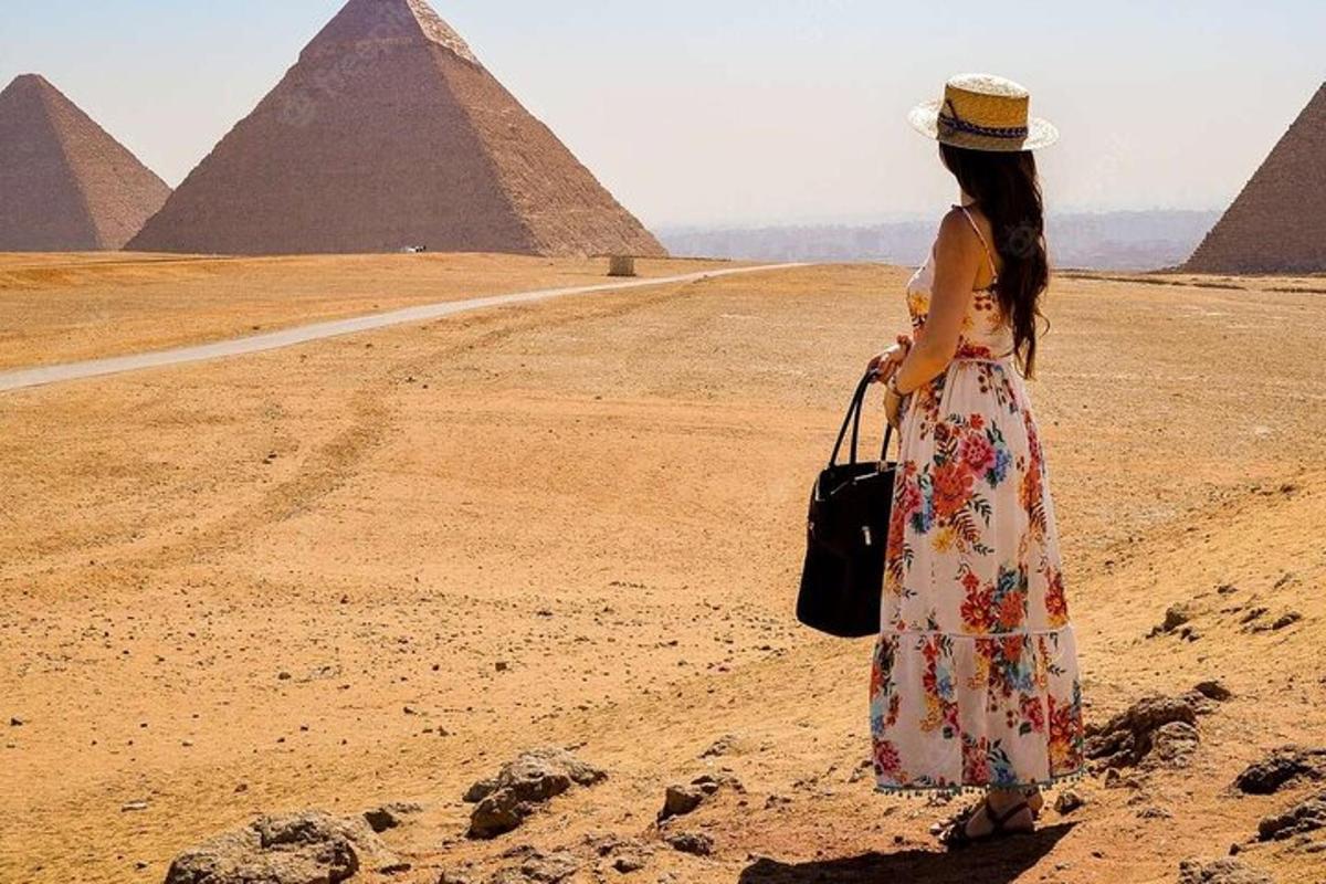 امرأة تقف أمام الأهرامات