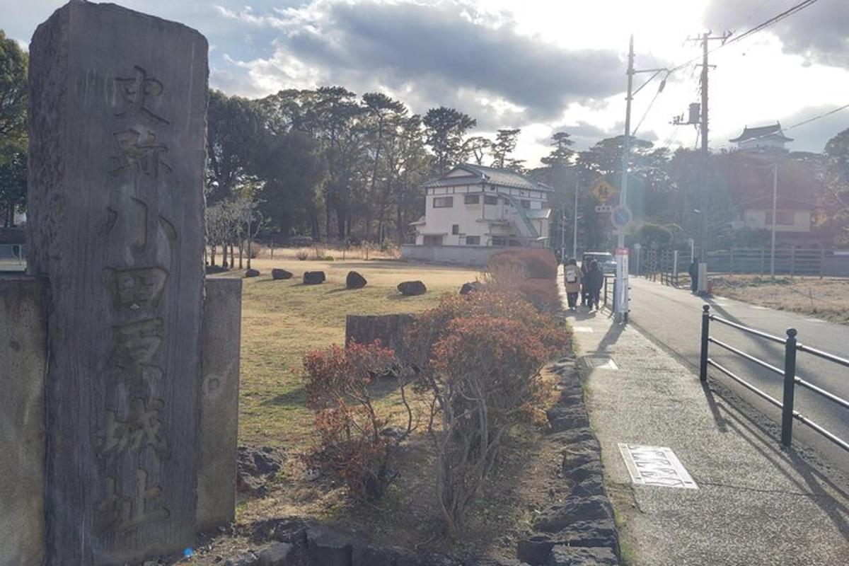 a sign on the side of a road next to a fence