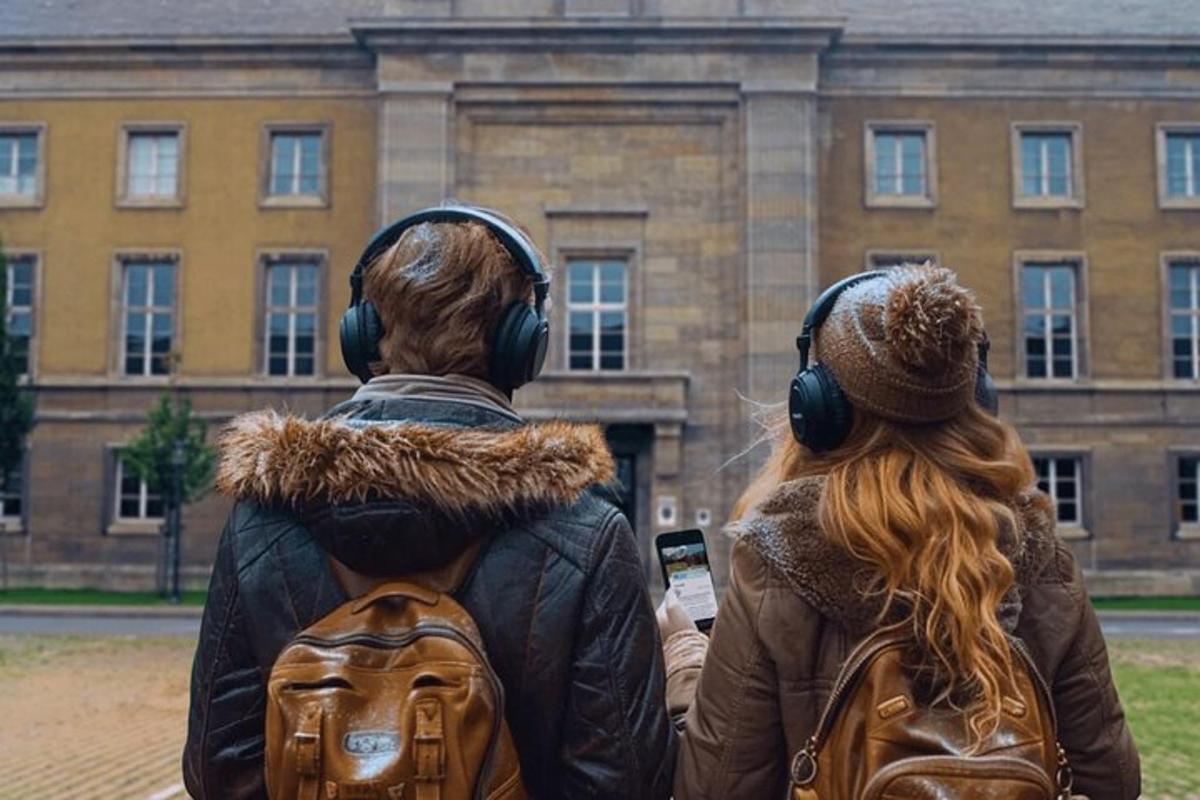 two people wearing headphones standing in front of a building