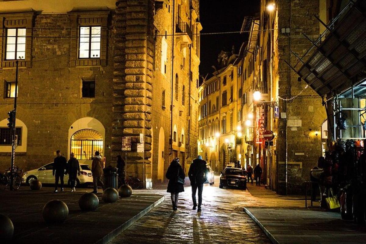 Un grupo de personas caminando por una calle de noche