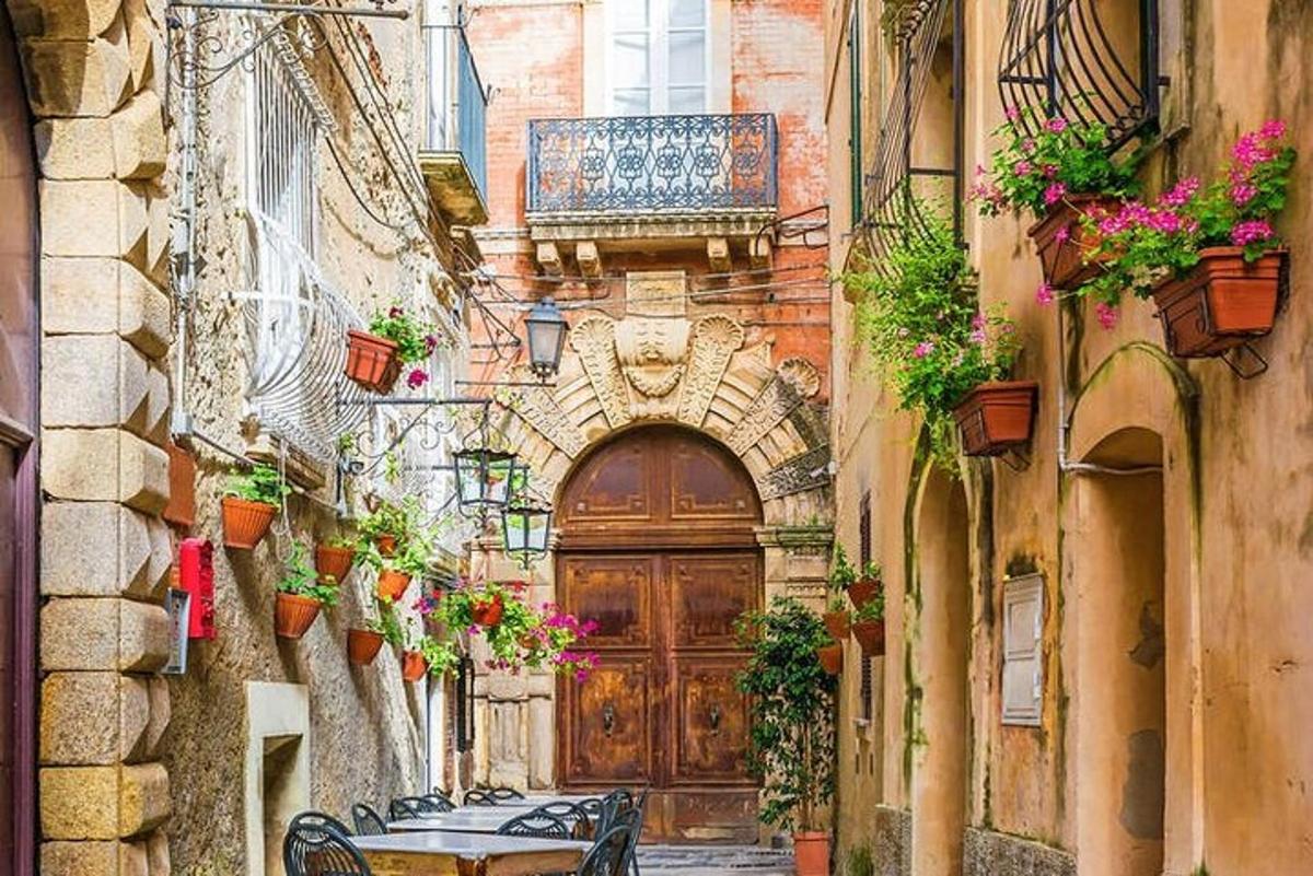 un vicolo con una grande porta di legno e un tavolo