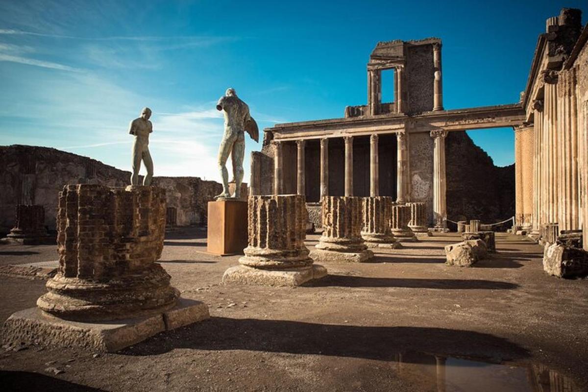 due statue di uomini in piedi su pilastri di fronte a un edificio