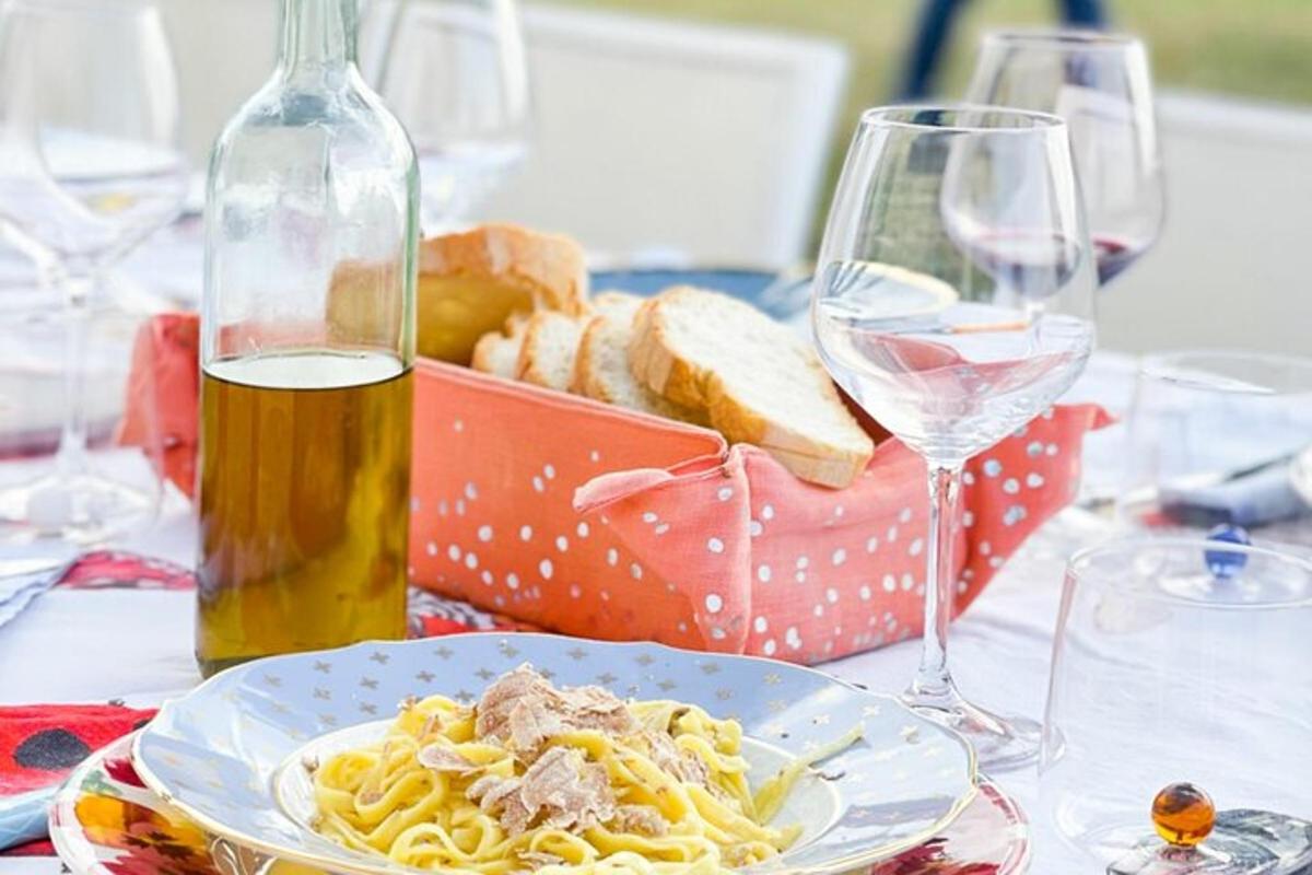 borð með pasta og flösku af víni