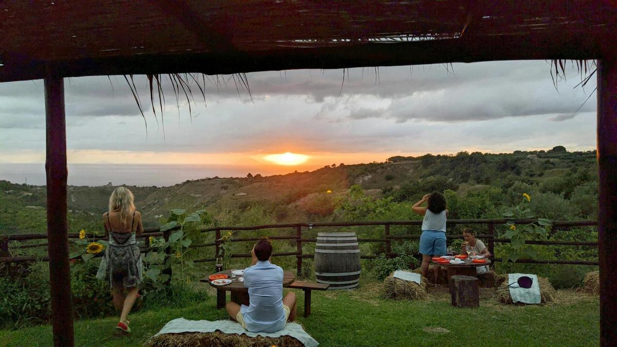 a group of people sitting at a table watching the sunset