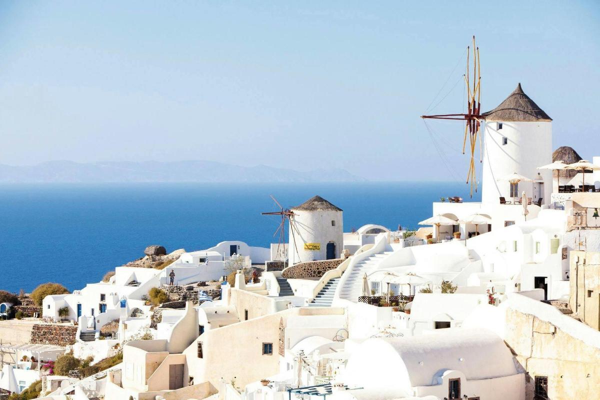 Una vista de una ciudad con edificios blancos y molinos de viento.