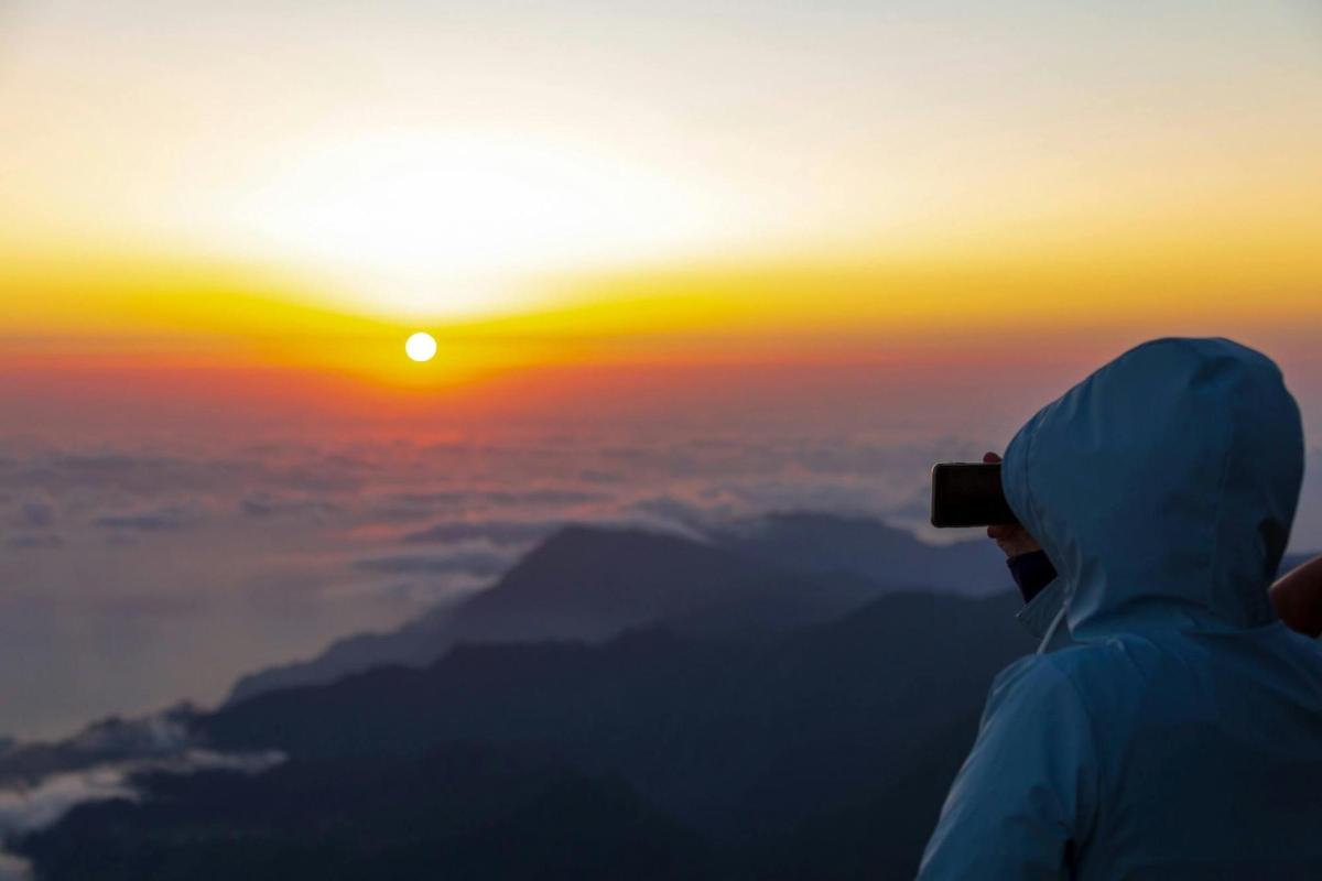 a person taking a picture of the sunset