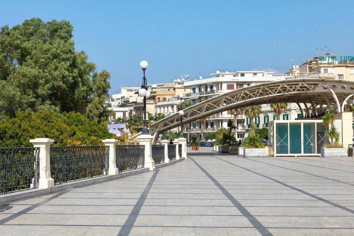 a bridge over a walkway with buildings in the background
