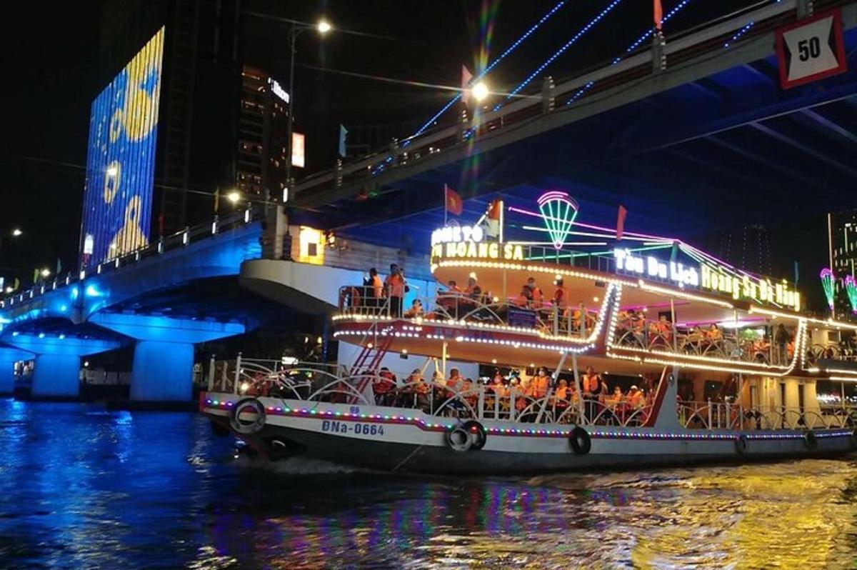 a boat filled with people on the water near a bridge