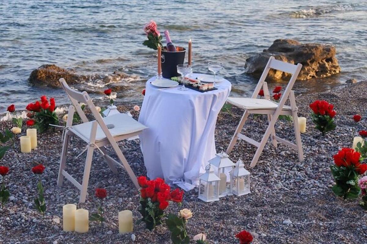 un tavolo con sedie e candele sulla spiaggia