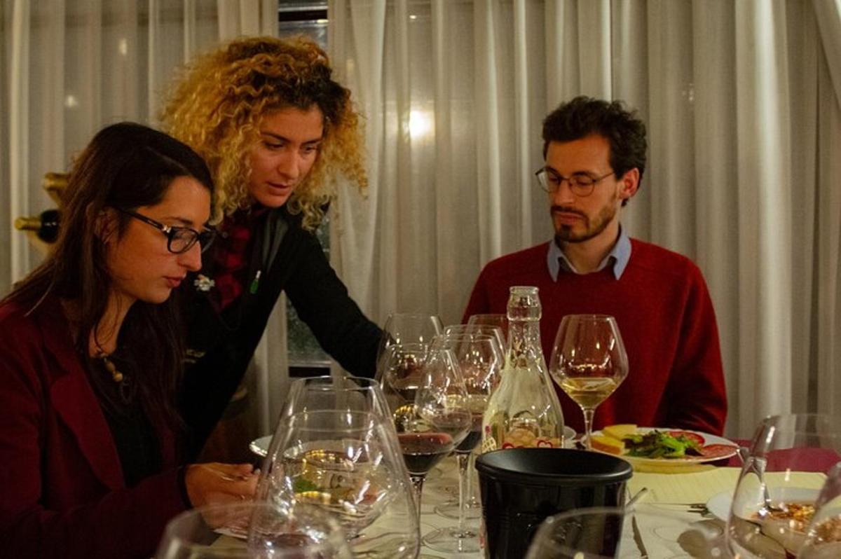 un grup de oameni așezați la o masă cu pahare de vin