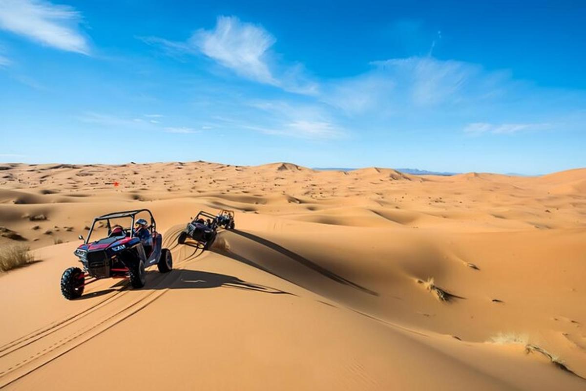 un veicolo che guida attraverso la sabbia nel deserto