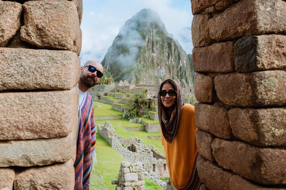 un uomo e una donna in piedi davanti a un muro di pietra