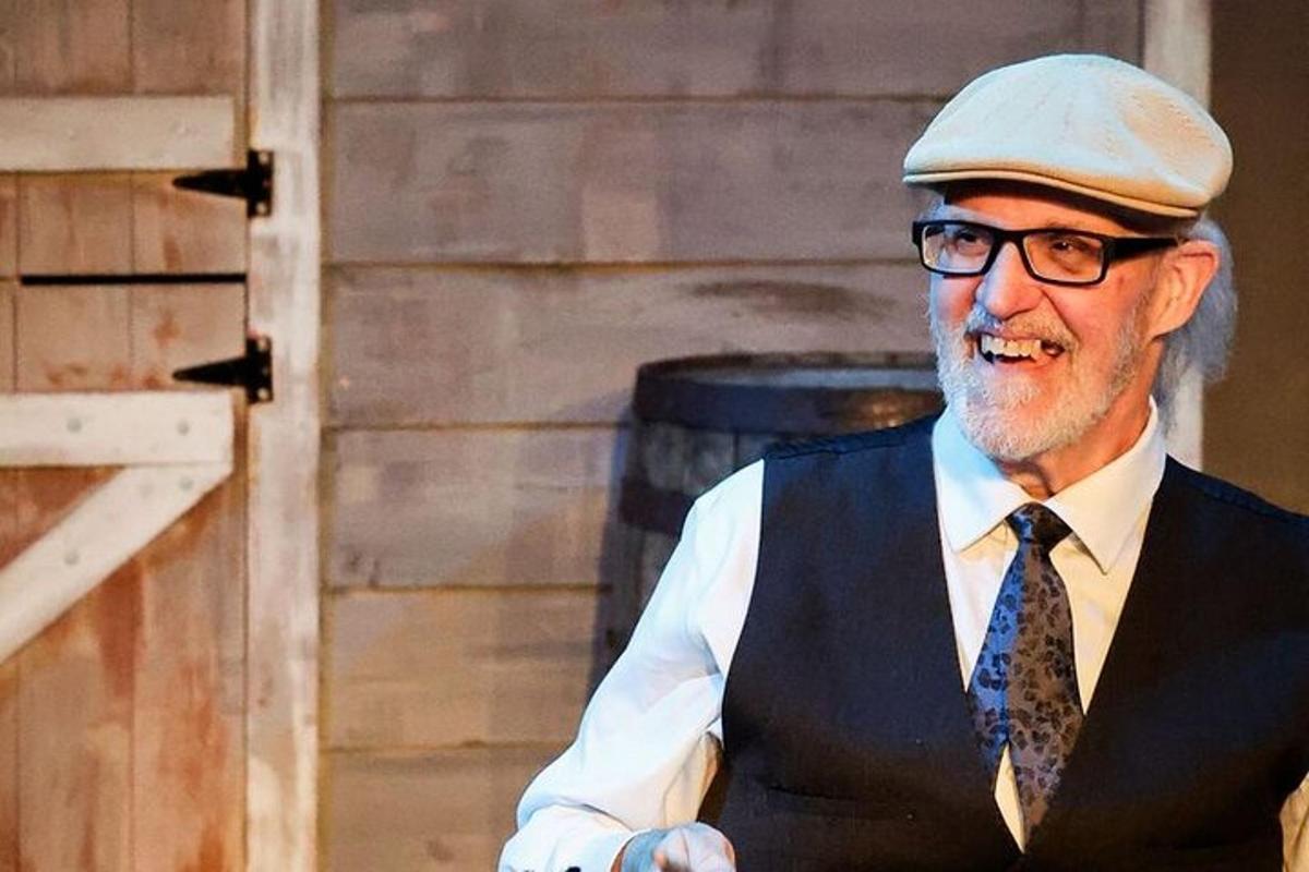 a man wearing a hat and a vest and tie
