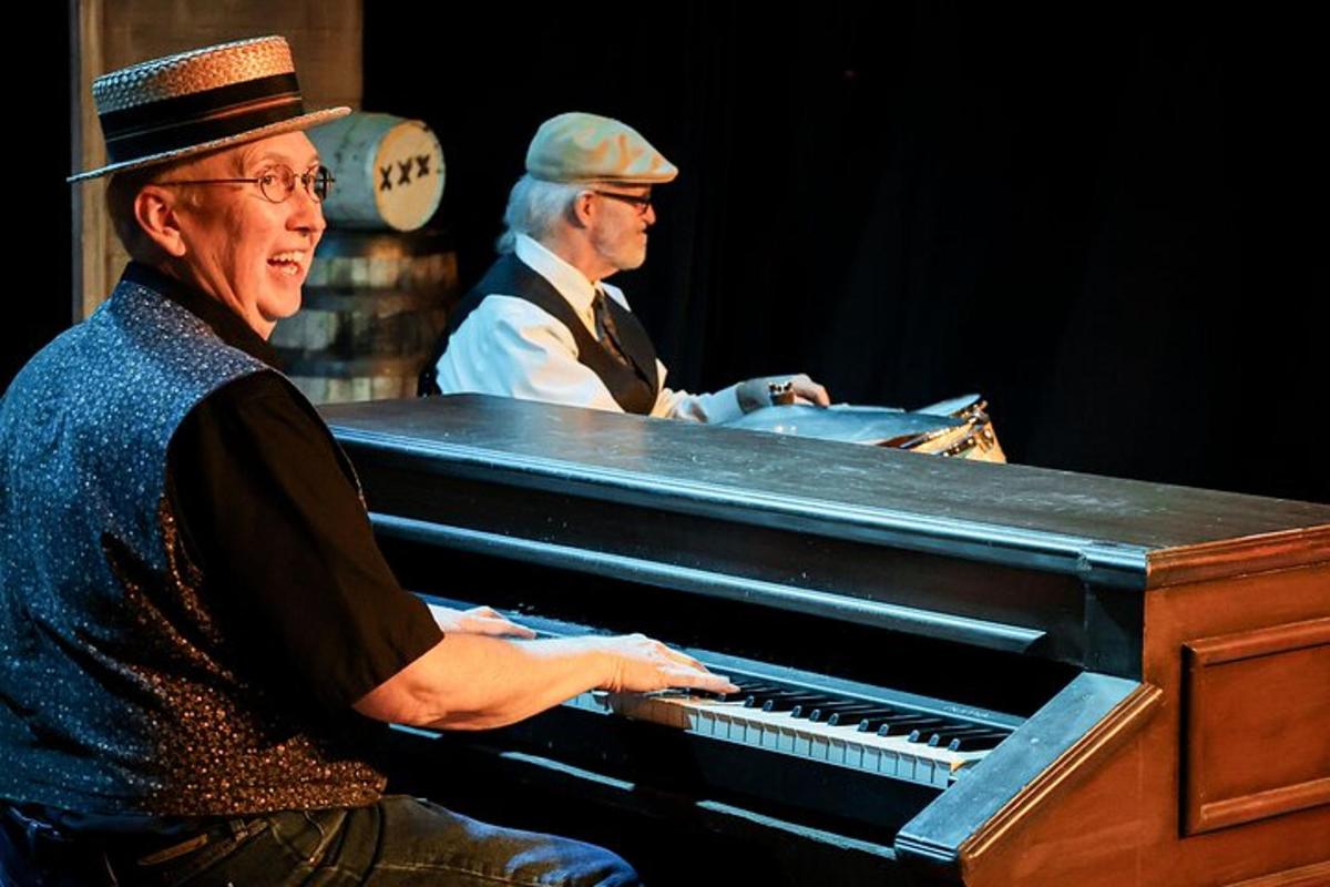 two men sitting at a piano in a room