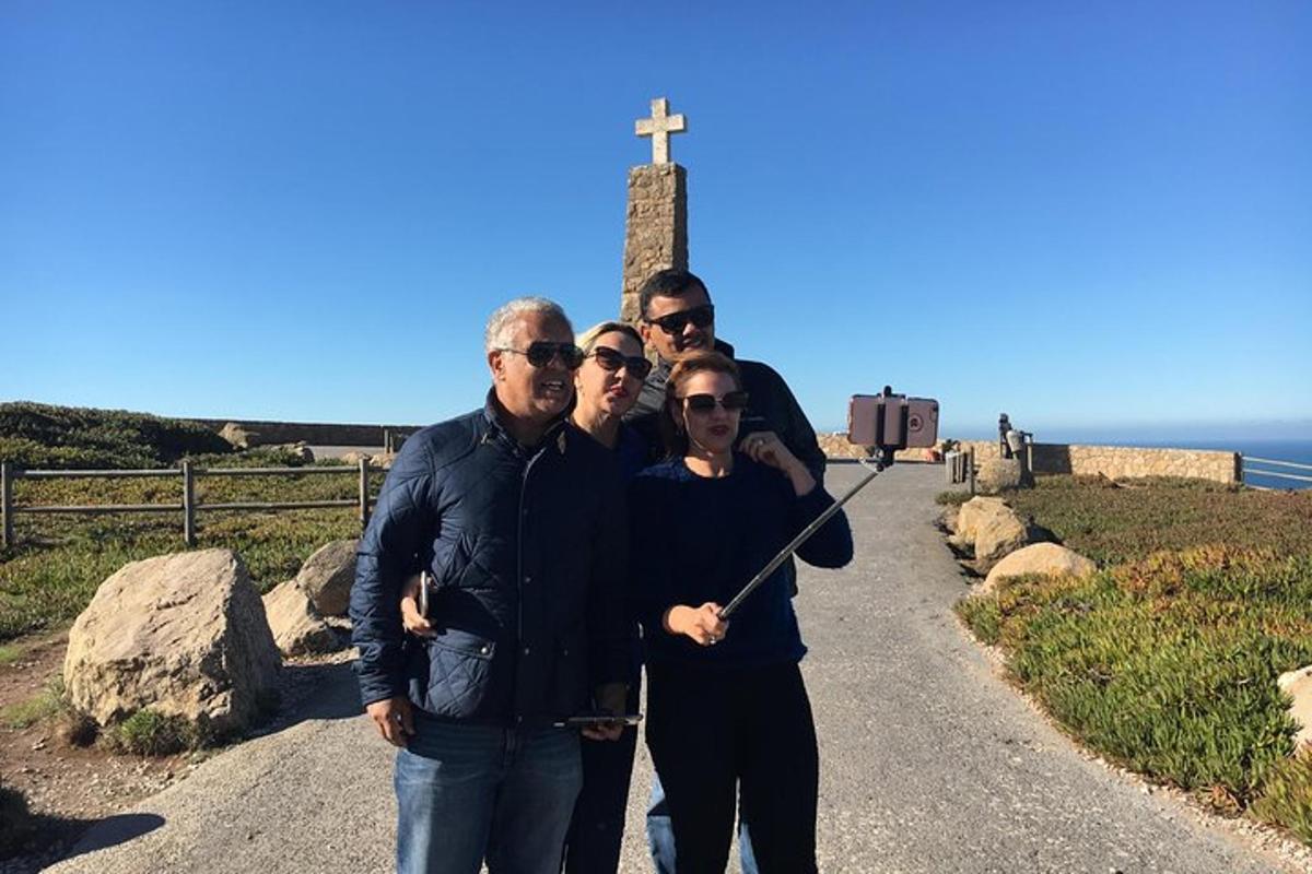 um grupo de pessoas em pé em frente a uma cruz