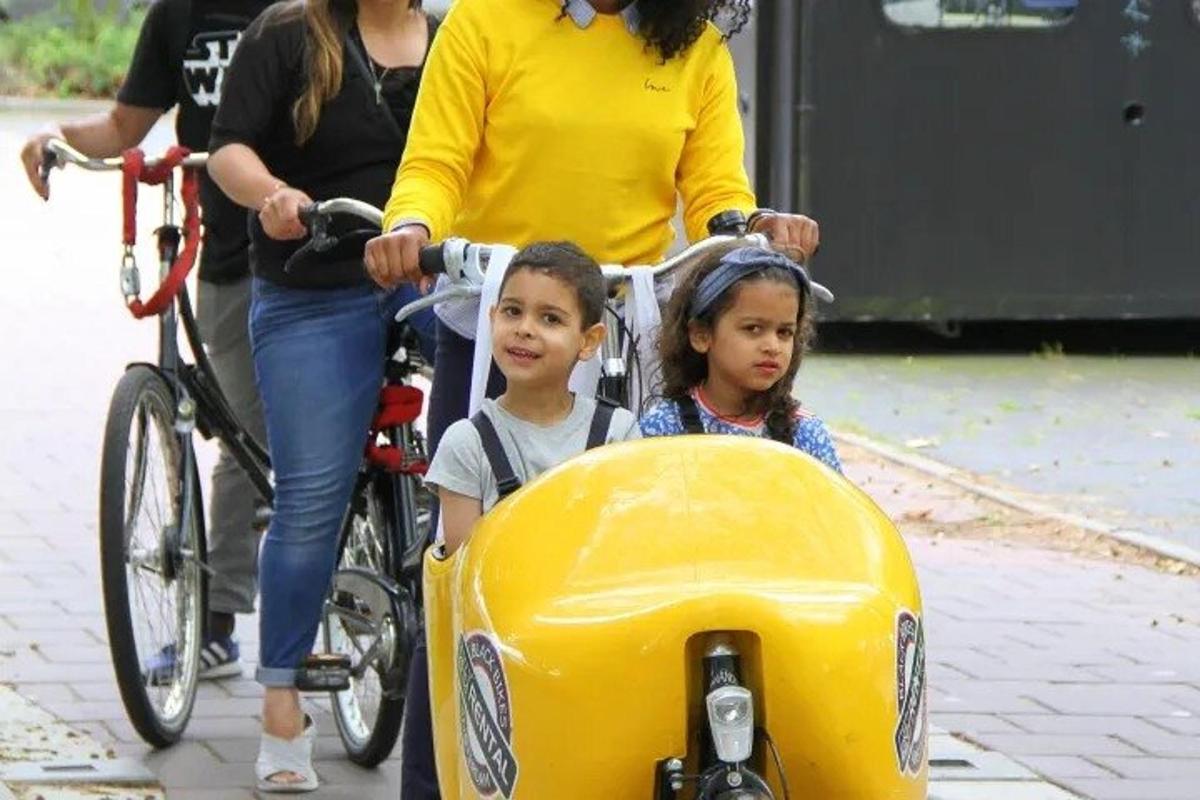 a woman and two children on a bike with a sidecar