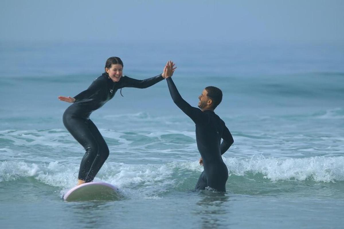 a man and a woman on a surfboard in the ocean