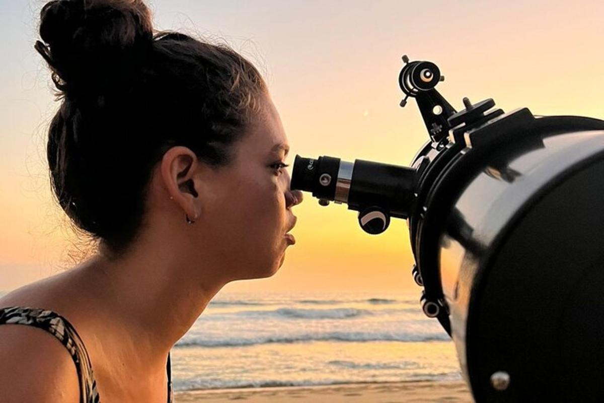 a woman looking through a camera on the beach