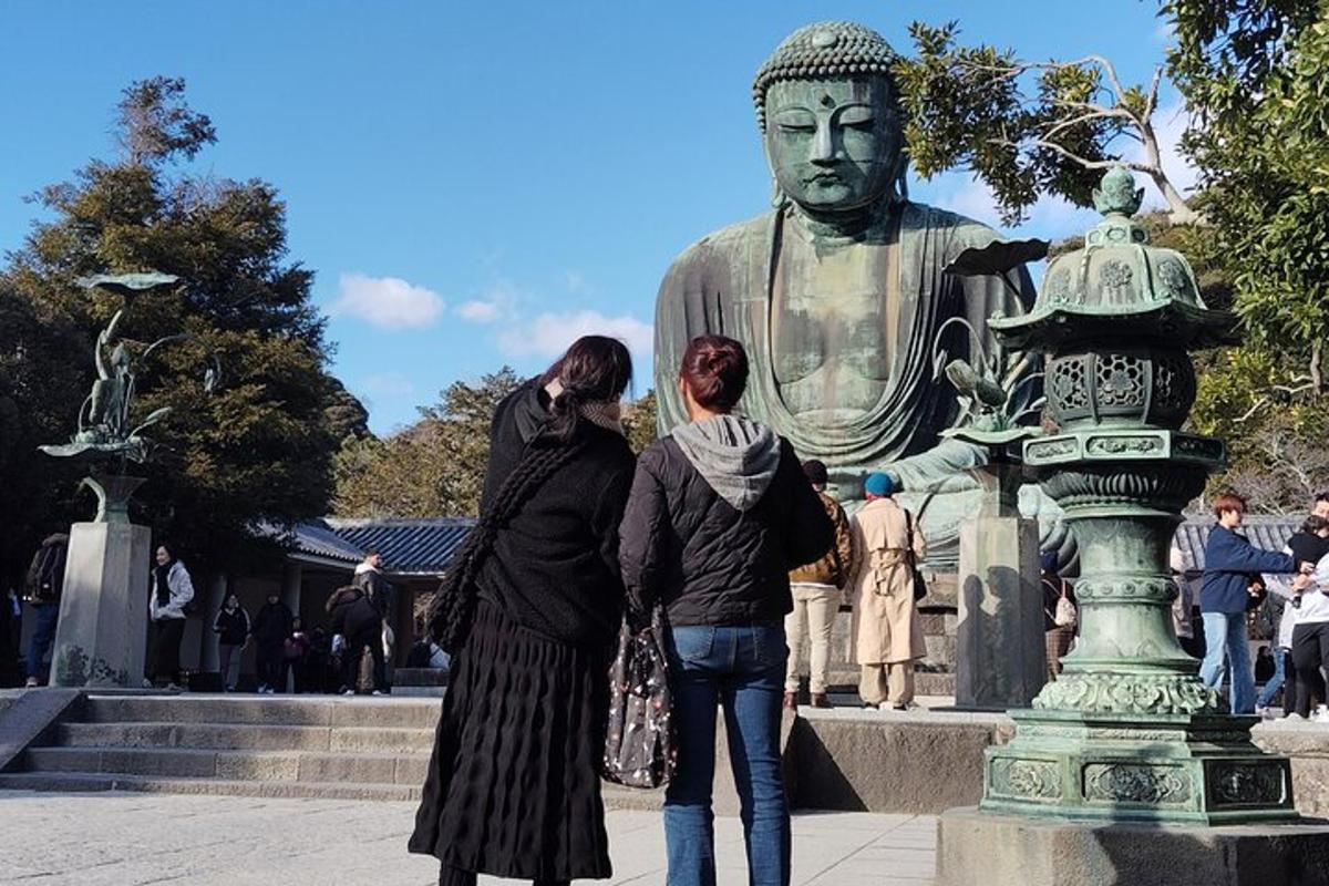 two women standing in front of a statue