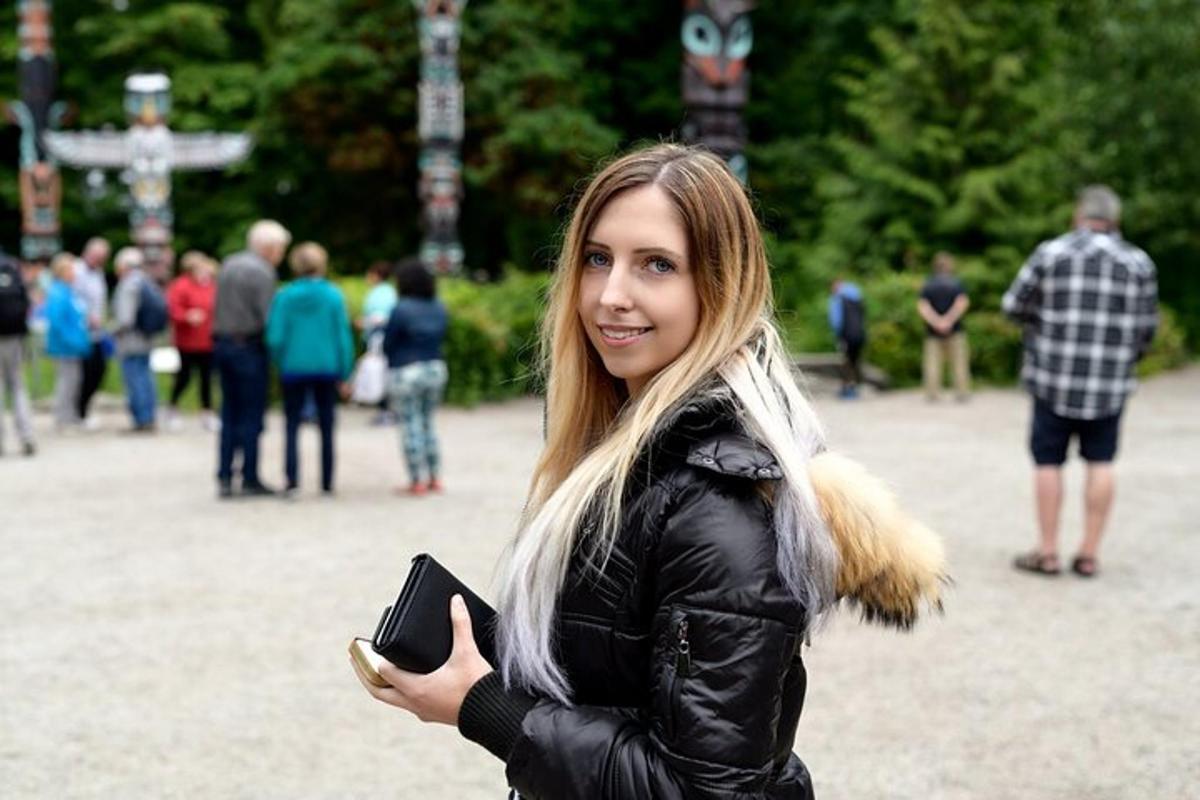 ženska v črni jakni, ki drži mobilni telefon
