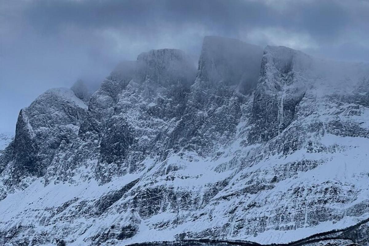 a mountain covered in snow and clouds