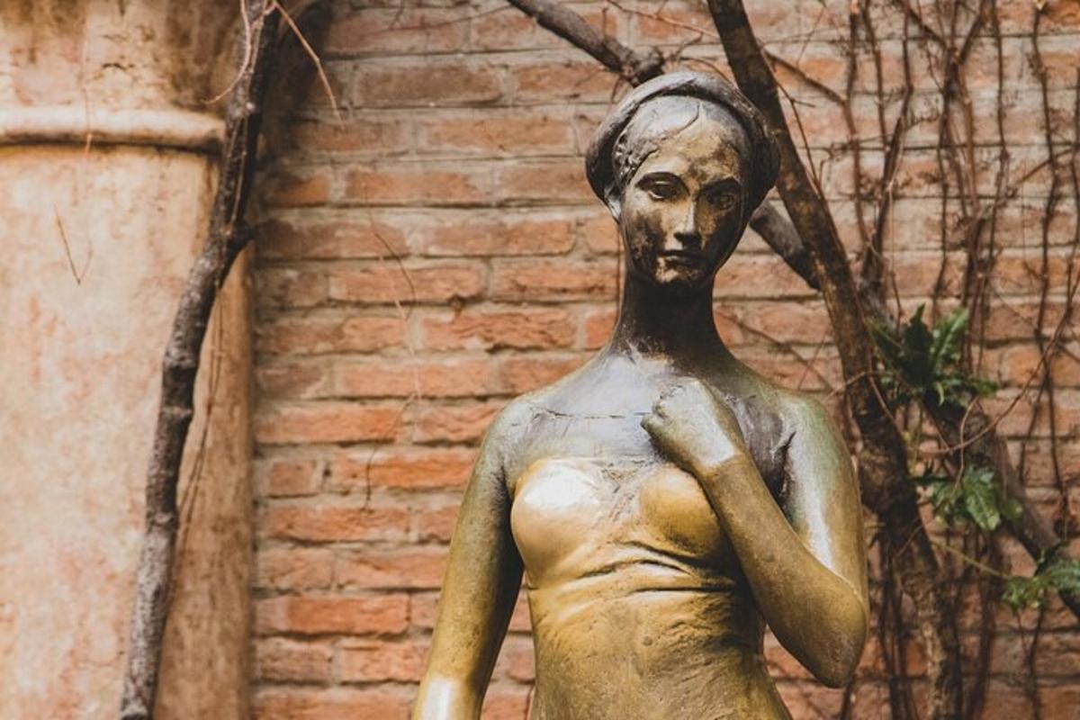 een standbeeld van een vrouw voor een bakstenen muur