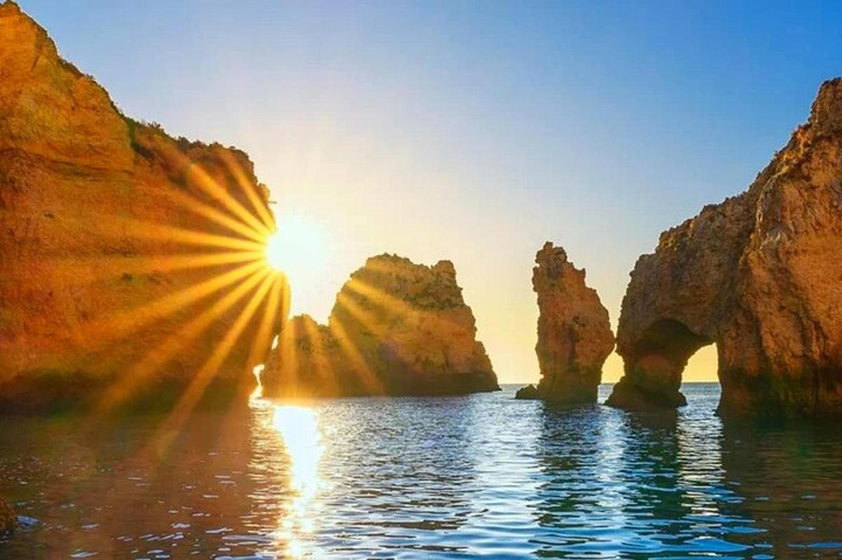 một mặt trời lặn trên đại dương với những tảng đá trong nước