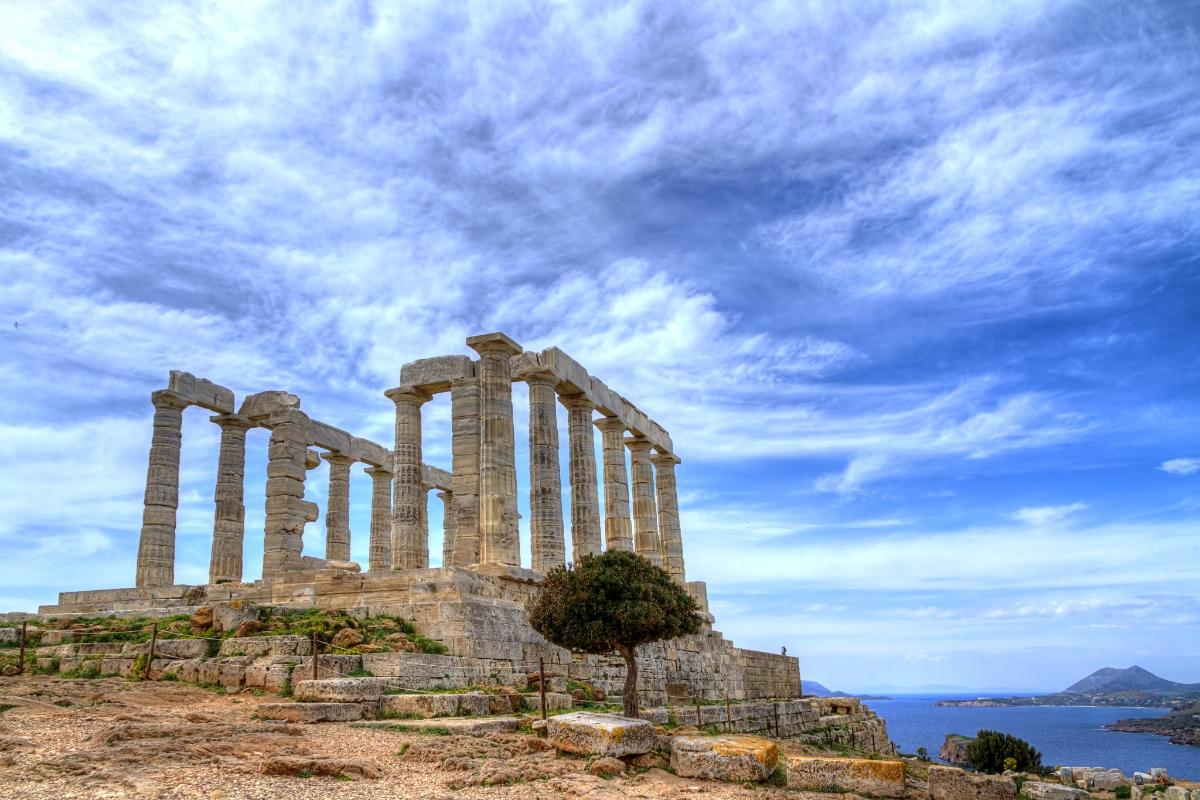 a temple on a hill with a cloudy sky