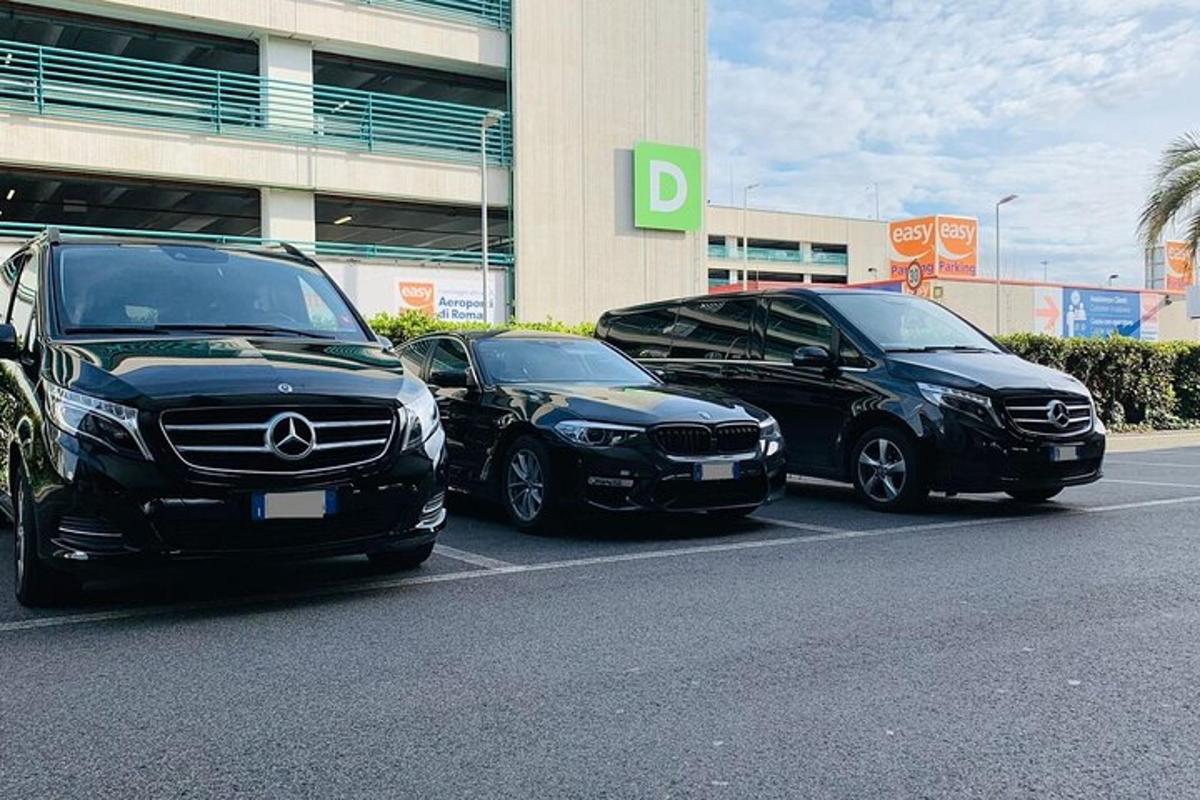 tři auta zaparkovaná na parkovišti před budovou