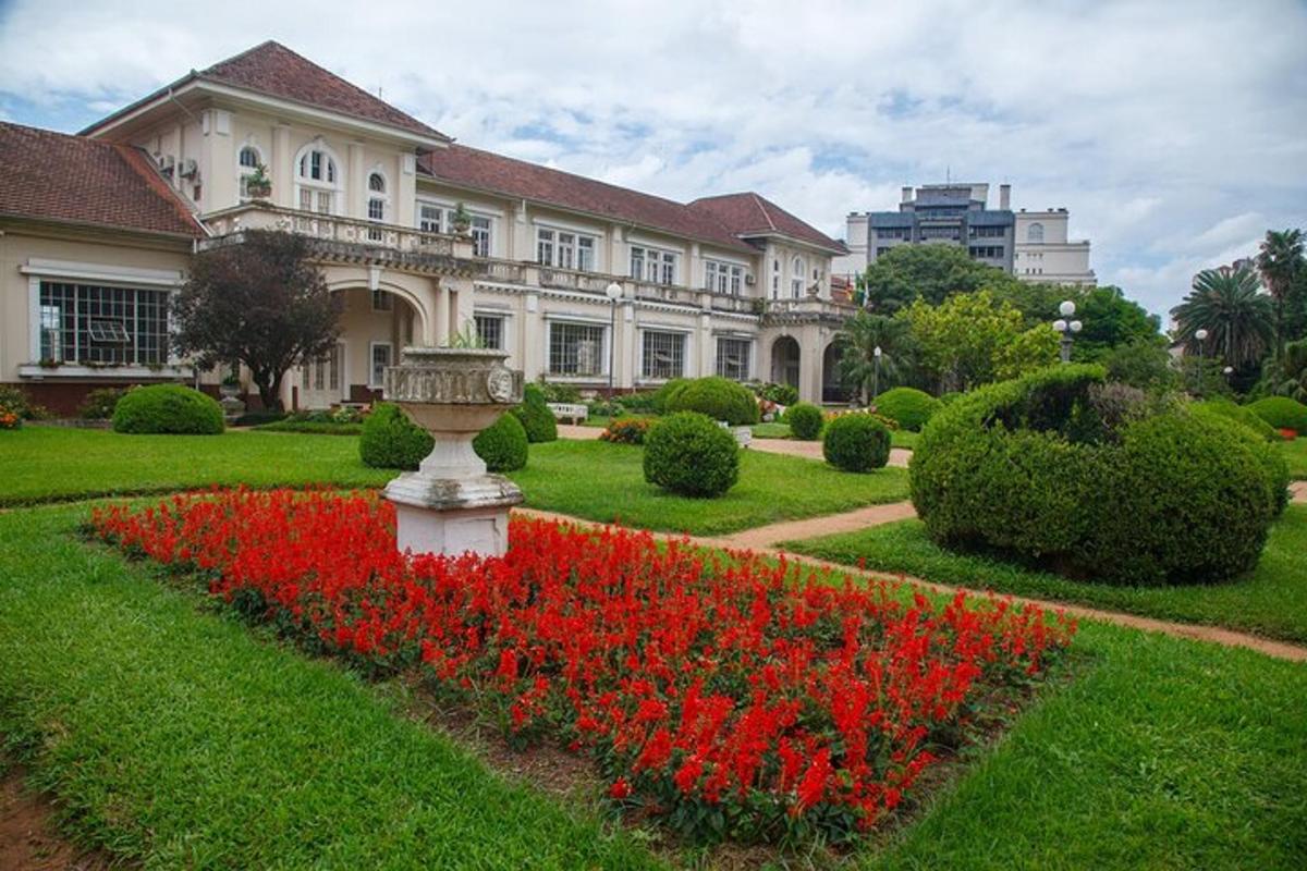 a large house with red flowers in front of it