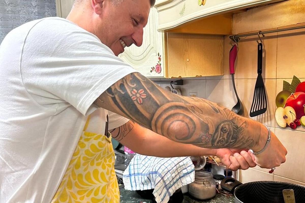 a man with a tattoo on his arm in a kitchen