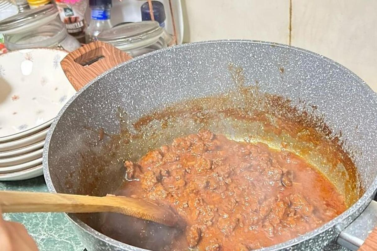 een pot met eten met een houten lepel erin