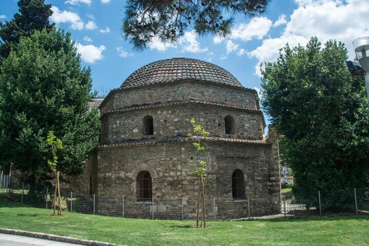 un vecchio edificio in pietra con una cupola sull'erba