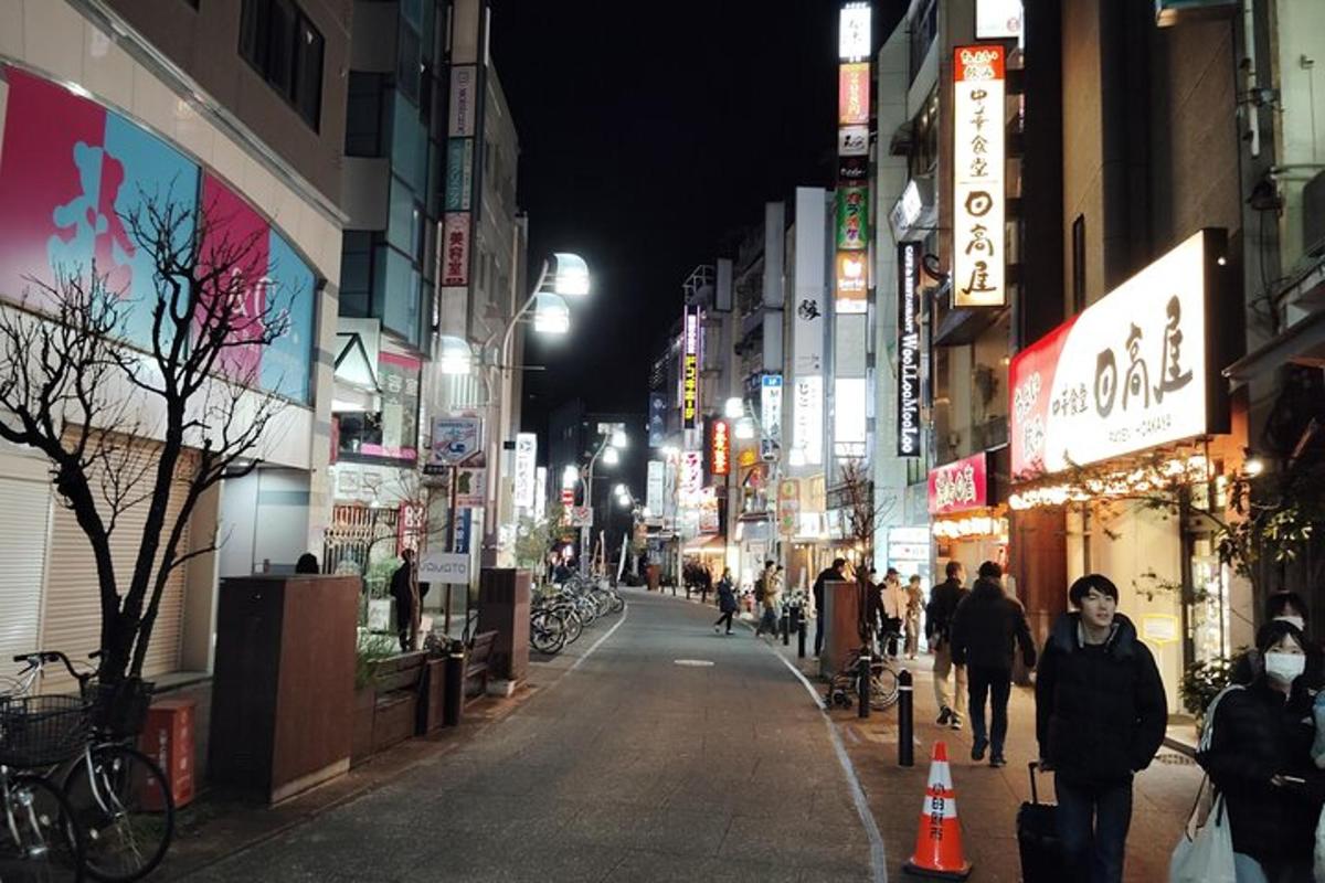 a city street at night with people walking down the street