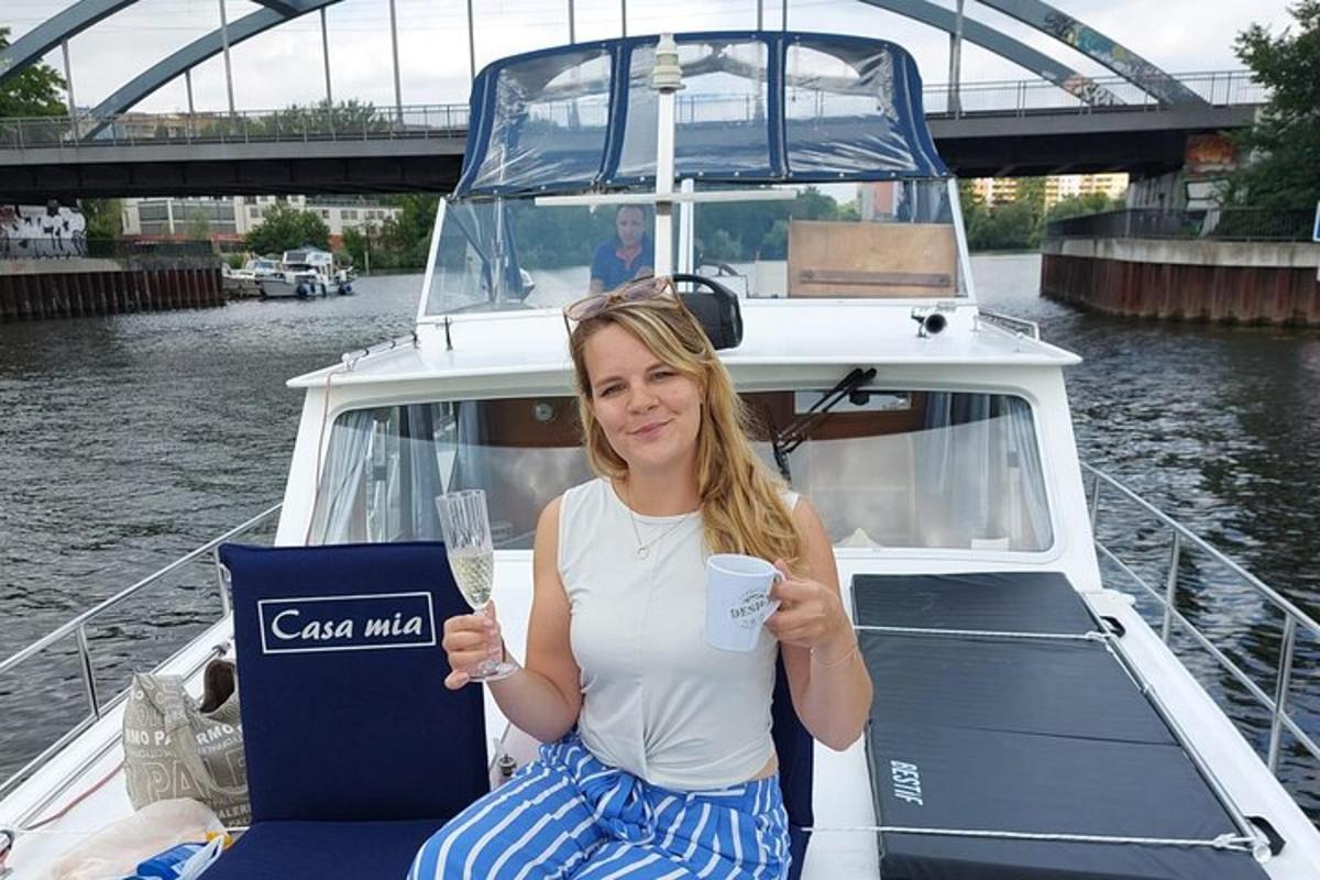 Una mujer sentada en un barco sosteniendo una copa de vino