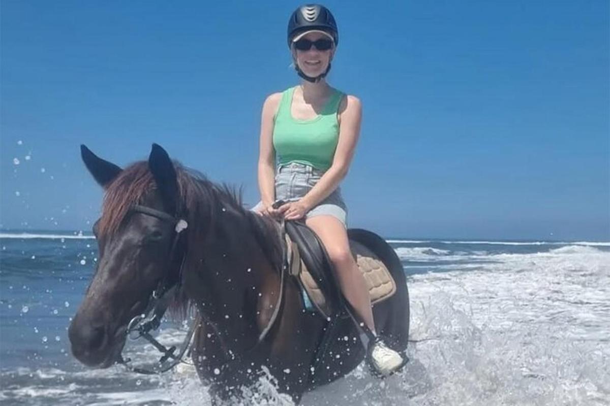 egy nő lovagol a tengerparton