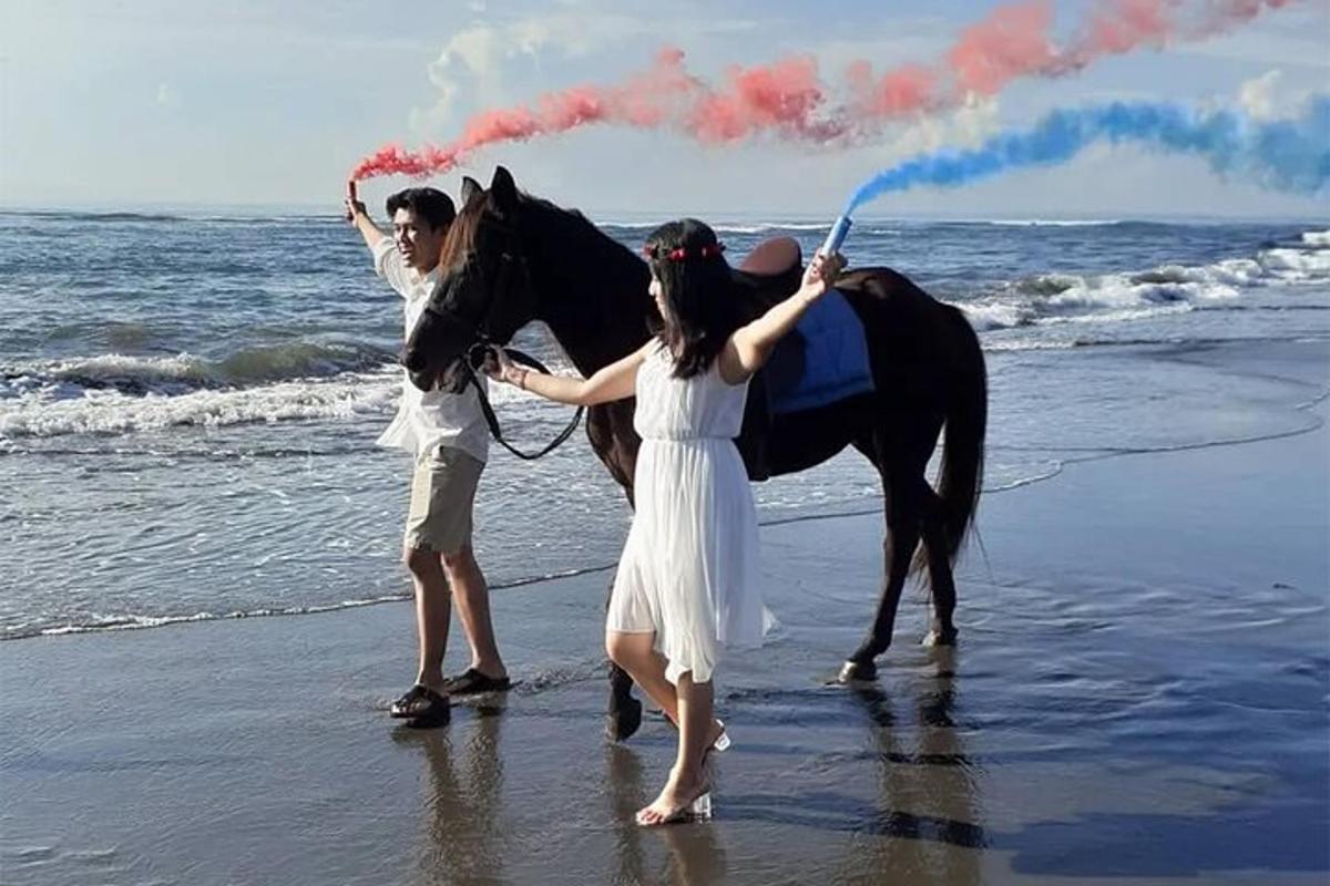 hai người phụ nữ và một con ngựa trên bãi biển với một cái vòi