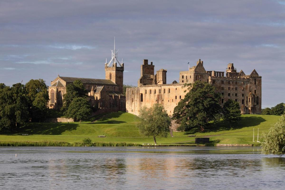 un castello su una collina vicino a uno specchio d'acqua