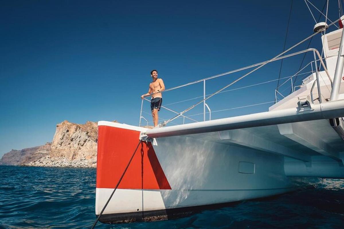 un uomo in piedi sul lato di una barca in acqua