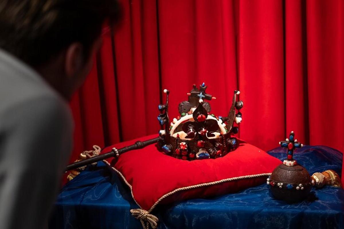 un uomo con una corona su un cuscino rosso