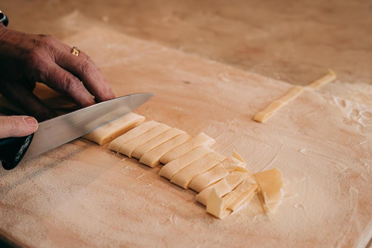 a person cutting up a carrot on a cutting board