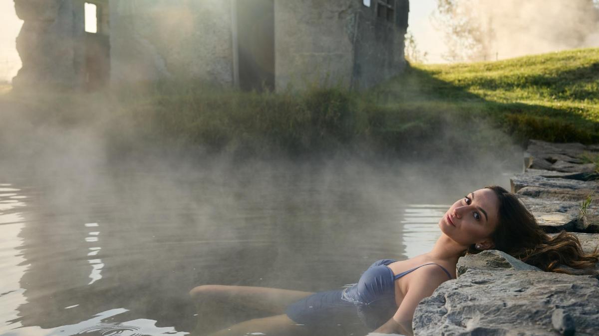 a woman laying in the water in a hot tub