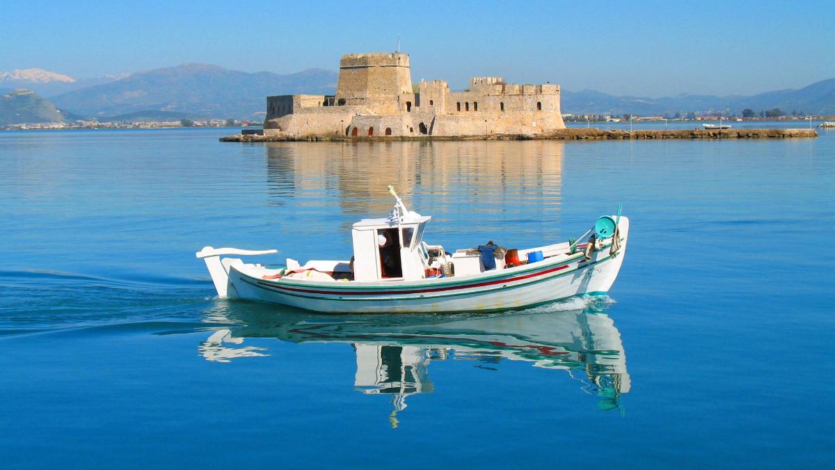 a boat in the water with a castle in the background