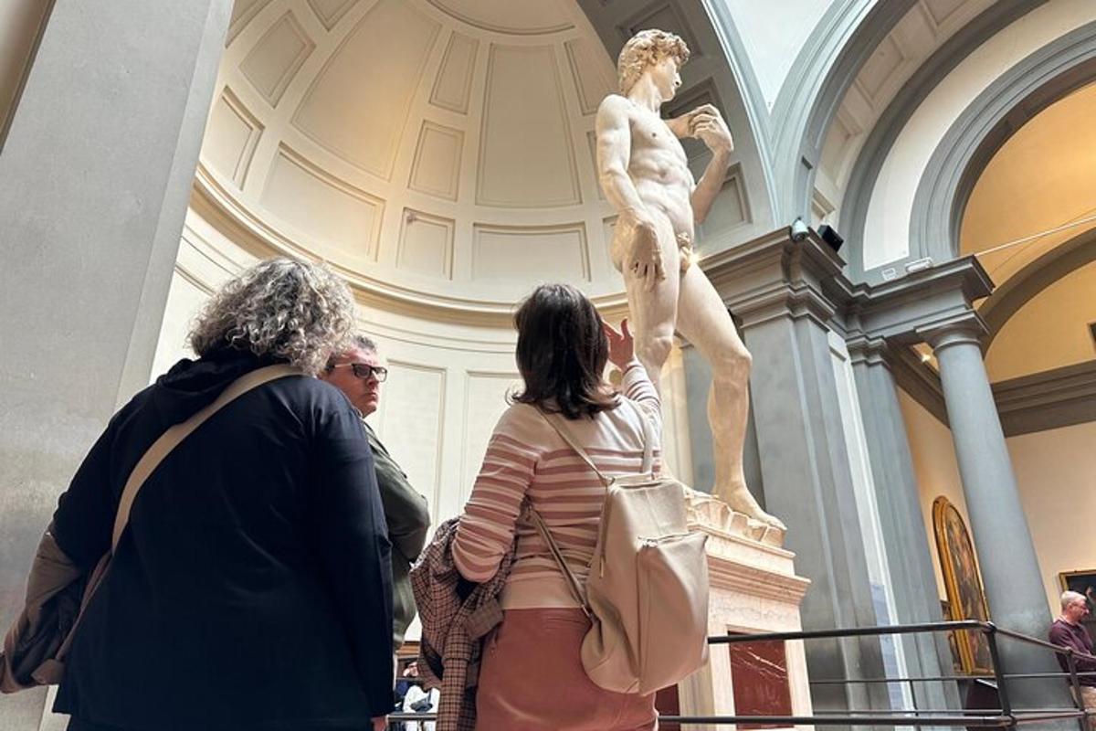 en gruppe mennesker som ser på en statue i et museum