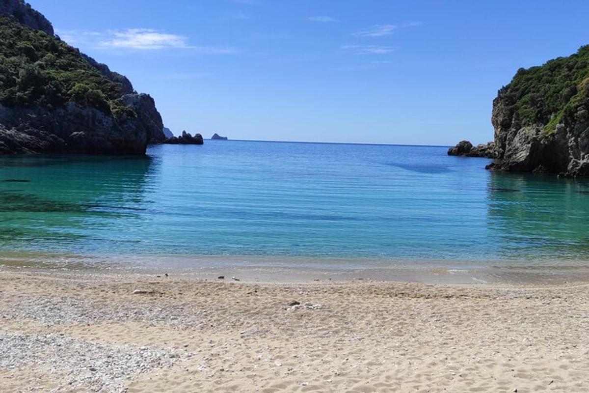 μια παραλία με γαλάζια νερά και βράχους στον ωκεανό