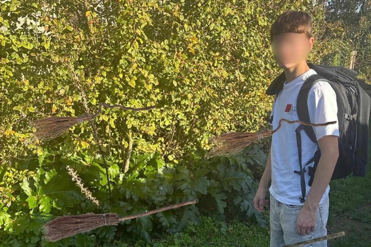mladý muž s batohom stojaci pred kríkom